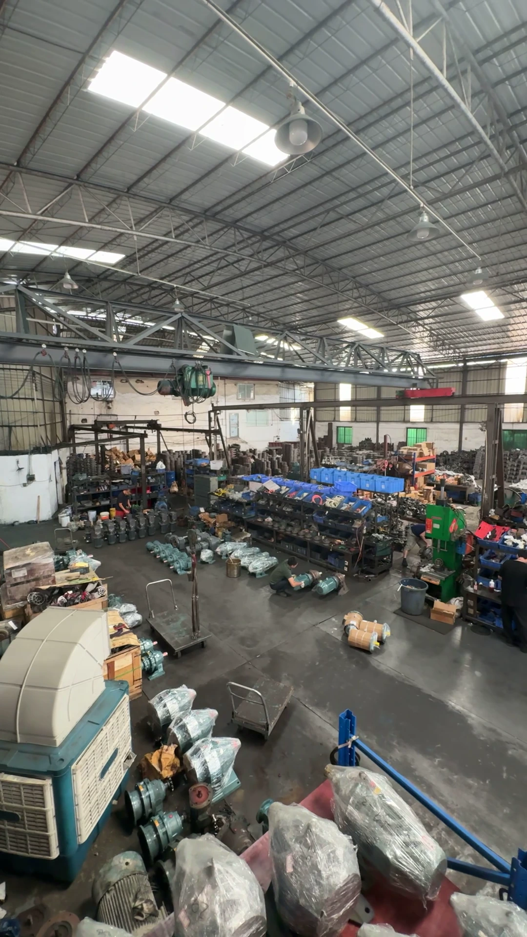 Factory floor with component racks, assembled units and people at work
